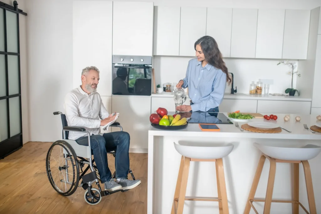 Disabled man in kitchen with support worker