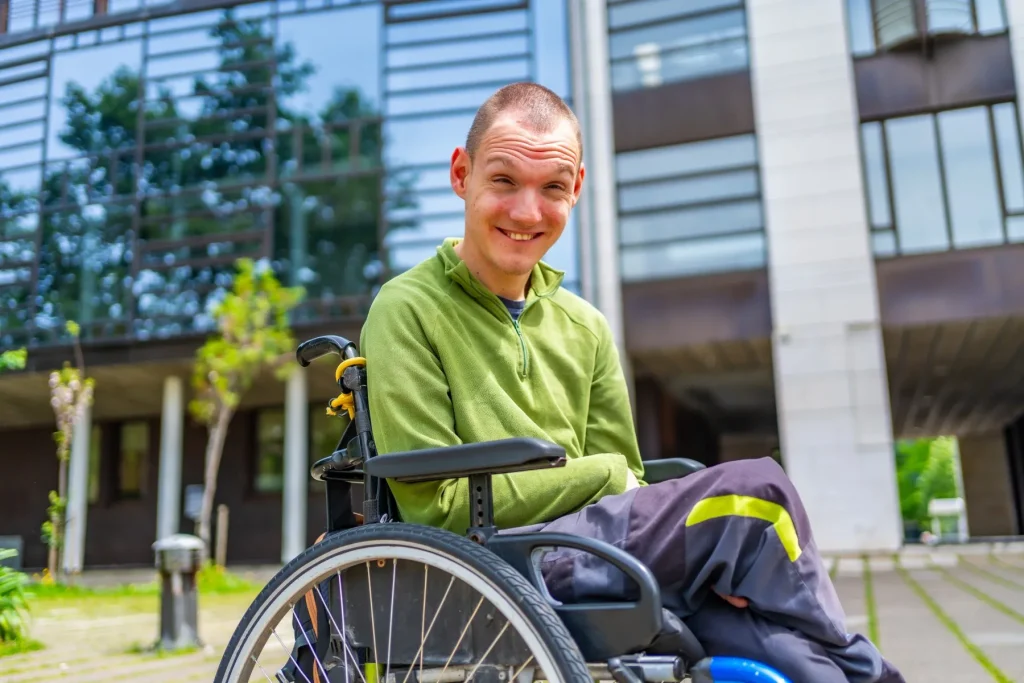 Disabled man in wheelchair smiling at camera