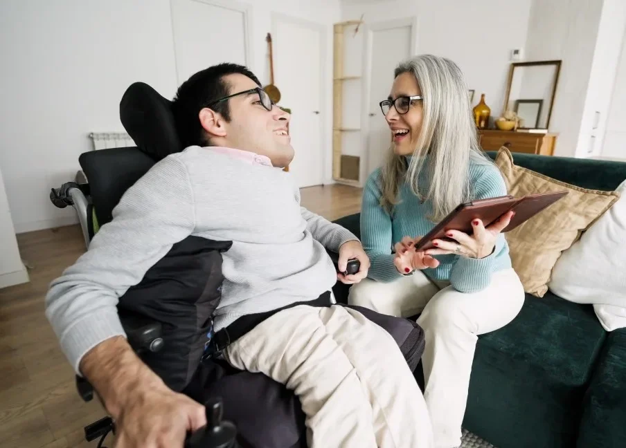 Disabled man laughing with support worker